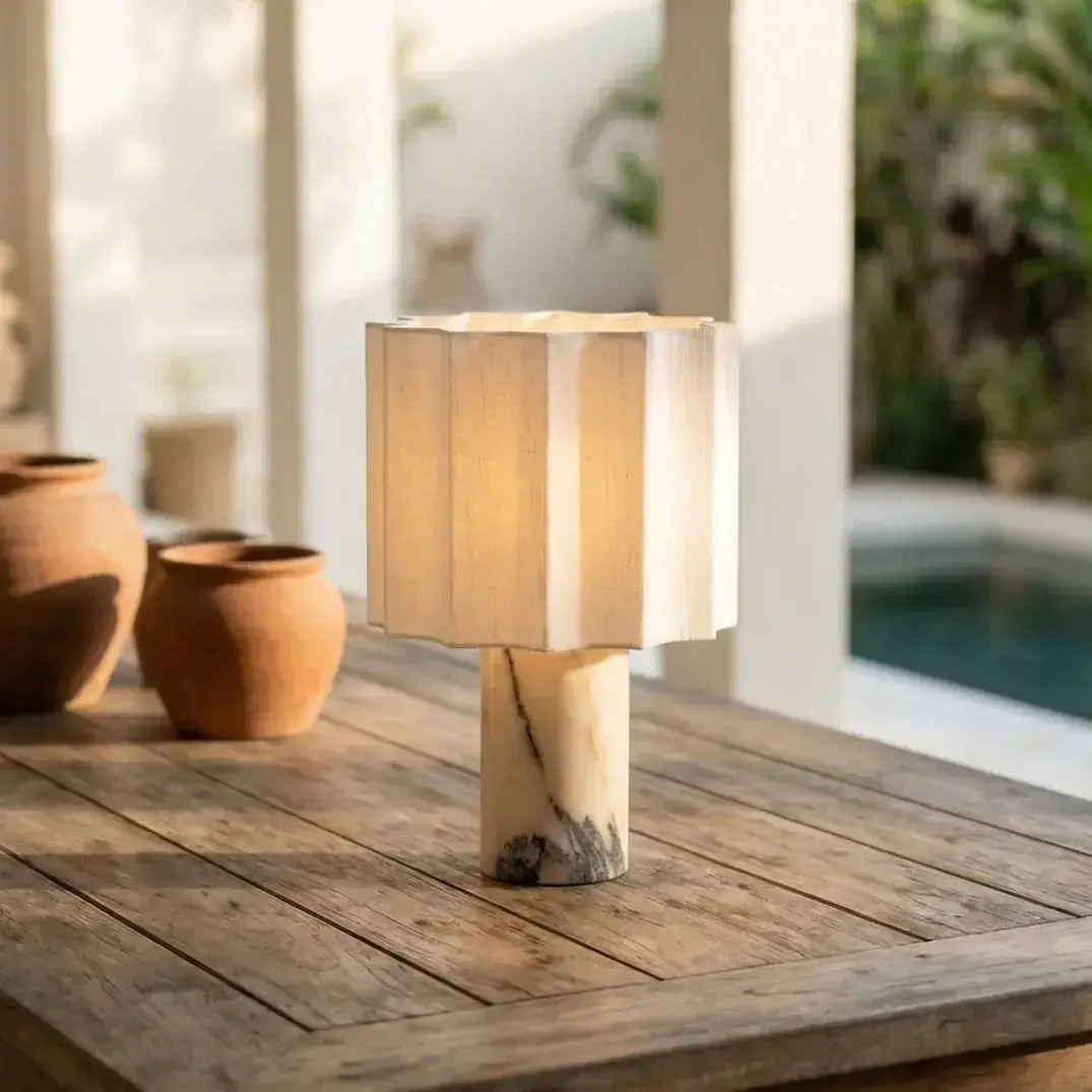 Petra Kastano lamp on a side table with books